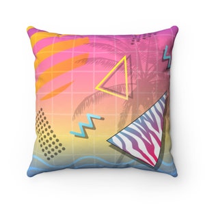 May include: A pink, orange and yellow throw pillow with a geometric pattern featuring a palm tree silhouette, zigzags and a zebra print.