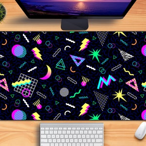May include: A black and white geometric patterned mousepad with a retro 80s design. The pattern includes shapes like triangles, squares, and zigzags in neon colors like pink, yellow, blue, and green.