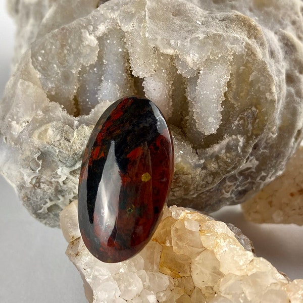 Oregon Jasper Cabochon Red and black in color, size is approximately  29mm x 16mm  with a gold fleck