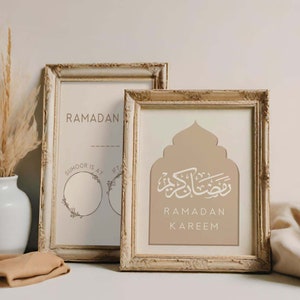 May include: Two framed prints with a beige background. The print on the left has the text "Ramadan" and "Suhoor is at" with a circle for writing in the time. The print on the right has a beige arch with Arabic calligraphy and the text "Ramadan Kareem".