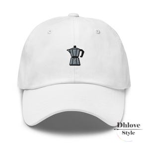 May include: White baseball cap featuring a black and grey embroidered coffee pot design. The cap has a curved peak and a classic six-panel construction. A stylish accessory for coffee enthusiasts.