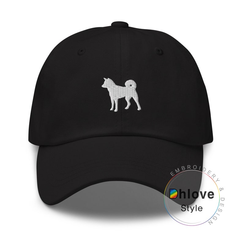 May include: Black baseball cap with a white embroidered Shiba Inu dog design. The cap has a curved brim and an adjustable strap. The text "Dhlove Style" is printed on the side.