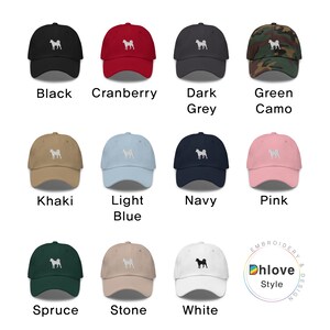 May include: A collection of baseball caps in various colors, including black, cranberry, dark grey, and green camo. Each cap features an embroidered dog silhouette. Additional colors are khaki, light blue, navy, pink, spruce, stone, and white.