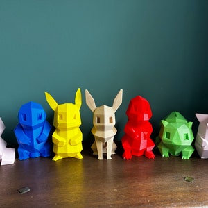 May include: A row of seven colorful, low-poly 3D printed figurines of popular cartoon characters. The figurines are arranged from left to right in the following colors: pink, blue, yellow, beige, red, green, and pink.