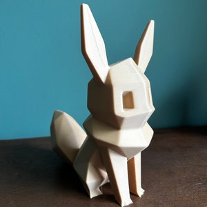 May include: A beige, low-poly, 3D printed figurine of a fox with pointed ears and a curled tail.