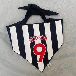 May include: Black and white striped bandana with a red and white name "HUDSON" and the number "9" in red.