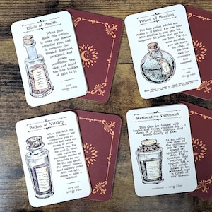May include: Four fantasy-themed cards with illustrations of potions and text descriptions. The cards are white with black ink drawings and text, featuring titles like "Elixir of Health" and "Potion of Heroism." Each card is paired with a burgundy card.