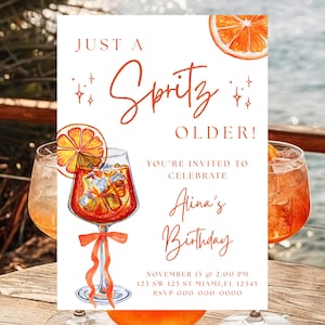 以下が含まれることがあります： オレンジ色の筆記体で「Just a Spritz Older!」と書かれた誕生日招待状。オレンジのスライスと氷の入ったスプリッツカクテルの水彩イラストが特徴です。招待状には「Alina」の名前とイベントの詳細が含まれています。
