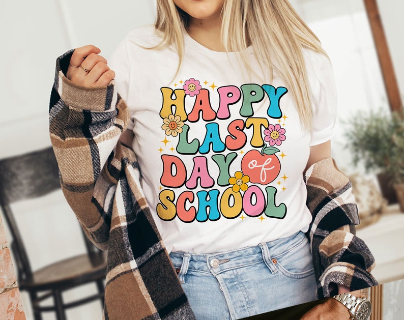 May include: White t-shirt with a colorful retro graphic that says "Happy Last Day of School" with flowers and an apple.