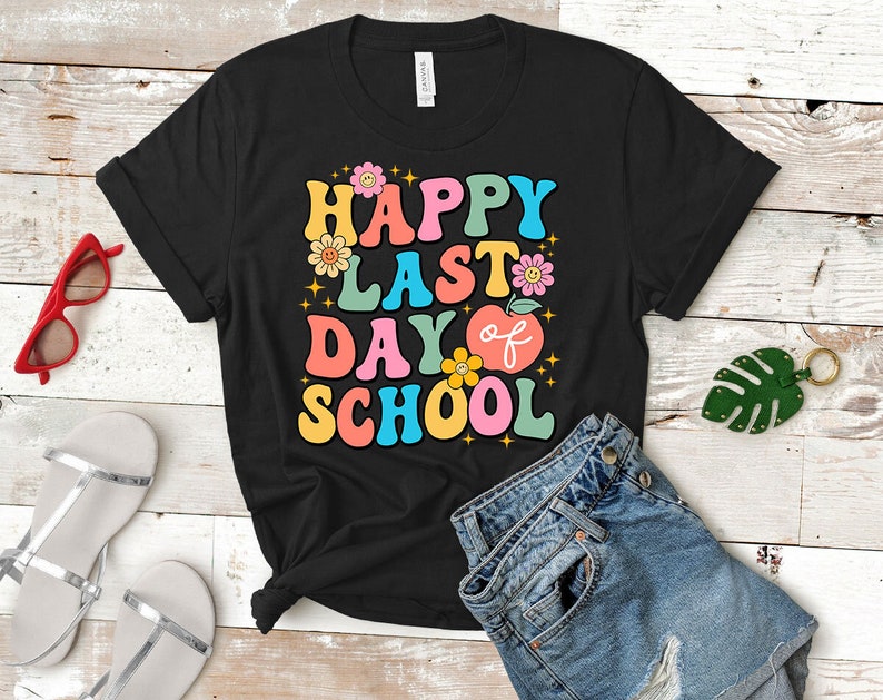 May include: Black t-shirt with a colorful retro graphic that says "Happy Last Day of School" with flowers and an apple.