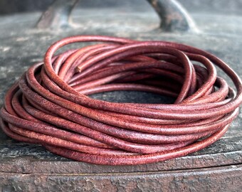 May include: A coil of reddish-brown leather cord. The cord is tightly wound, displaying its texture and colour. The image is a close-up, highlighting the material's details. The cord appears durable and suitable for various crafting projects.