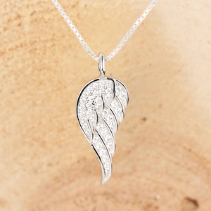 May include: A silver necklace with a single, clear crystal angel wing pendant.