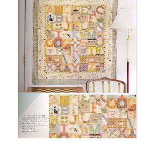 May include: A colorful alphabet quilt with a patchwork design. The quilt features a variety of fabrics and patterns, including floral prints, gingham, and polka dots. The quilt is framed by a simple border and is displayed on a wall.
