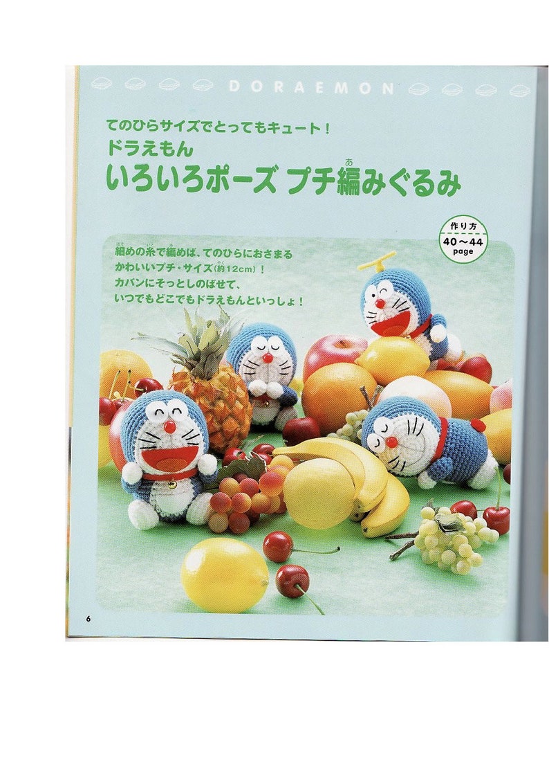 May include: Four crocheted Doraemon plushies in different poses, surrounded by fruit, including bananas, cherries, grapes, lemons, apples, and a pineapple. The plushies are approximately 12 inches tall. The text on the page reads "Doraemon" and "Various Poses Crochet Amigurumi."