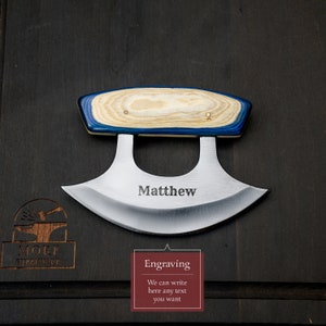 May include: A personalized, stainless steel,  curved blade knife with a blue and wood grain handle. The knife is engraved with the name "Matthew".