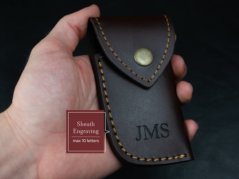 May include: A brown leather sheath with a flap and a gold button. The sheath has a gold stitch around the edges and the initials "JMS" are engraved on the front.  Sheath Engraving max 10 letters.