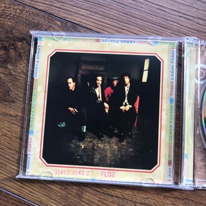 May include: A CD case with the album artwork for "Sonic Lemon Parade." The cover shows four individuals in dark attire, seated. The CD is in a clear plastic case. The text "31453 1042 2 FL'02" is printed on the bottom of the cover.