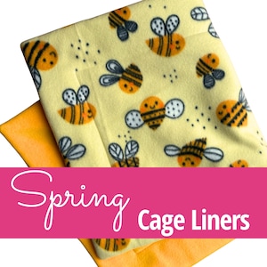 May include: A soft fabric cage liner featuring a repeating pattern of cartoon bees with orange bodies and black stripes on a pale yellow background, layered over a solid orange fabric, with the text Spring Cage Liners overlaid in white.