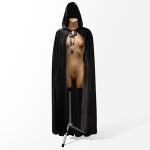 May include: A black velvet hooded cape with a black ribbon tie. The cape is draped over a mannequin.