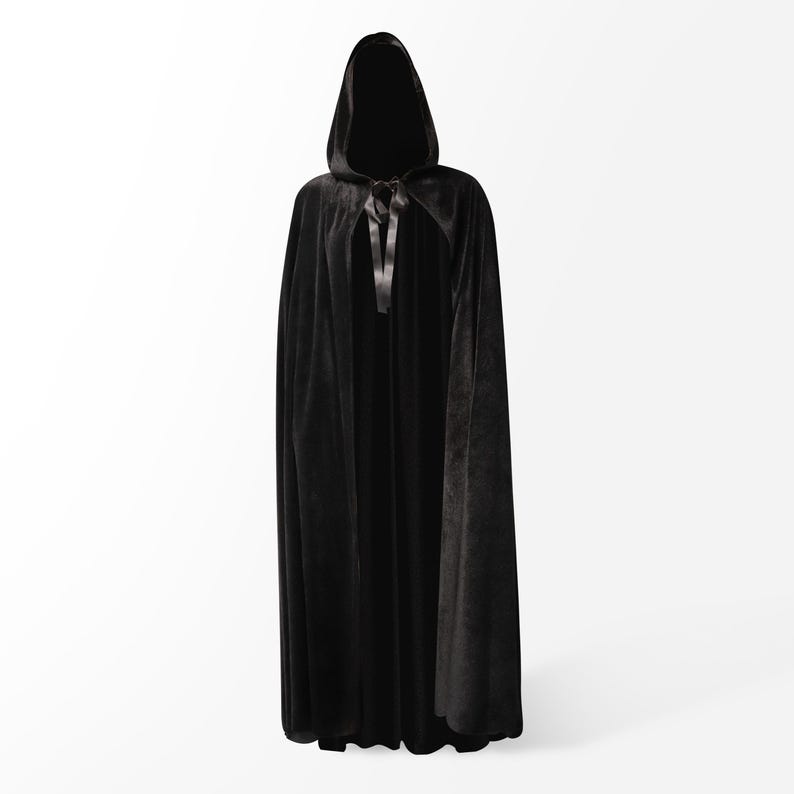 May include: A black velvet hooded cape with a black satin tie. The cape is long and flowing, and the hood is large and covers the head.