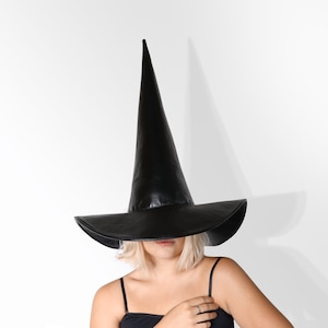 May include: A black witch hat with a tall, pointed crown and a wide brim. The hat is made of a smooth, shiny material.