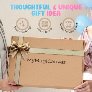 K&ouml;nnte beinhalten: Ein brauner Karton mit einem goldenen Band und Schleife. Der Karton ist mit "MyMagiCanvas" beschriftet und hat oben drei Symbole: einen Stern, ein Geschenk und ein Paar. Der Text "Gedankenvolles & einzigartiges Geschenkidee" befindet sich &uuml;ber den Symbolen.