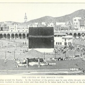May include: A black and white photo of a large crowd of people gathered around a black cube-shaped building. The building is surrounded by a courtyard with a fence and a few trees. The photo is taken from a high angle, looking down on the crowd. The text "THE CENTER OF THE MOSLEM FAITH" is printed below the image.