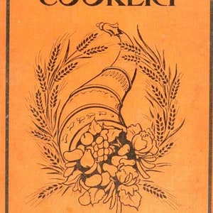 May include: An orange book cover with the title "VEGETARIAN COOKERY" in black text. The cover features a black and white illustration of a cornucopia overflowing with fruit and vegetables, surrounded by wheat stalks. The text "Edited by 'ISOBEL'" is at the bottom of the cover.