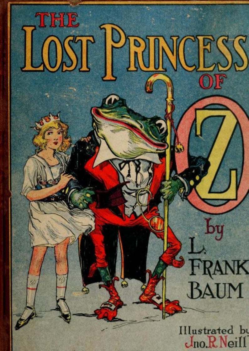 以下が含まれることがあります： L. フランク・バウムによる「オズの迷子の王女」の表紙イラスト。表紙には、赤いスーツと白いシャツを着て杖を持った緑色のカエルが描かれている。白いドレスと王冠をつけた若い女の子がカエルの隣に立っている。背景は青で、ピンクの円の中に大きな金の文字「Z」がある。