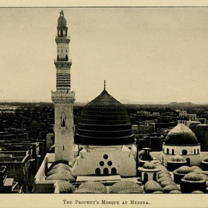 May include: A black and white photograph of the Prophet's Mosque in Medina, Saudi Arabia. The mosque has a large dome and a tall minaret. The mosque is surrounded by buildings and trees.