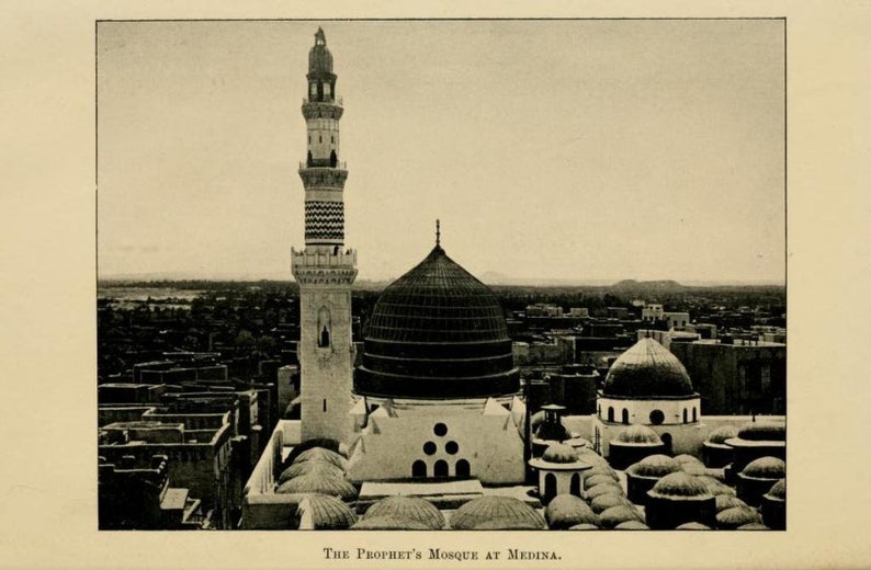 May include: A black and white photograph of the Prophet's Mosque in Medina, Saudi Arabia. The mosque has a large dome and a tall minaret. The mosque is surrounded by buildings and trees.