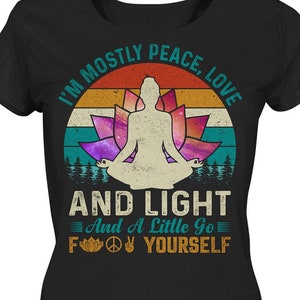 Könnte beinhalten: Schwarzes T-Shirt mit einem Grafikdesign, das eine meditierende Figur vor einer Lotusblume vor einem Sonnenuntergangshintergrund zeigt. Der Text lautet: „I'm mostly peace, love, and light and a little go f yourself.“