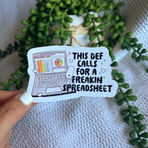 May include: White sticker with a cartoon laptop with a spreadsheet and a mouse. The text on the sticker reads "This def calls for a freakin spreadsheet".
