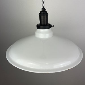 May include: White enamel pendant light fixture with a black cord and black socket.