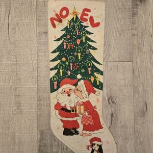 May include: A vintage Christmas stocking with a white background and a green Christmas tree with ornaments and candles. Santa Claus and Mrs. Claus are kissing under the tree. The stocking has the word "NOEL" printed in red letters.
