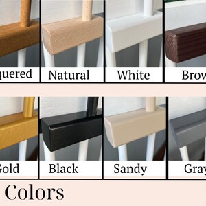 May include: A close-up of ten different color options for a wooden crib rail. The colors are lacquered, natural, white, brown, gold, black, sandy, gray, and two shades of gray.
