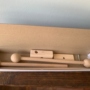May include: A set of wooden curtain rods with round finials, packaged in a cardboard box. The rods are unfinished and ready to be painted or stained.