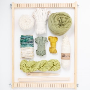 Peut inclure: Un métier à tisser en bois avec une variété de fils et de cordes de couleur verte, blanche et jaune. Le fil est disposé en grille sur le métier à tisser. Le métier à tisser est étiqueté "silento".