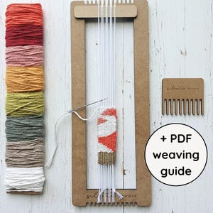 May include: A craft weaving kit with a wooden loom, a comb, and a selection of colorful yarn in shades of red, orange, pink, yellow, green, and white. The kit includes a partially woven sample and the text "+ PDF weaving guide".