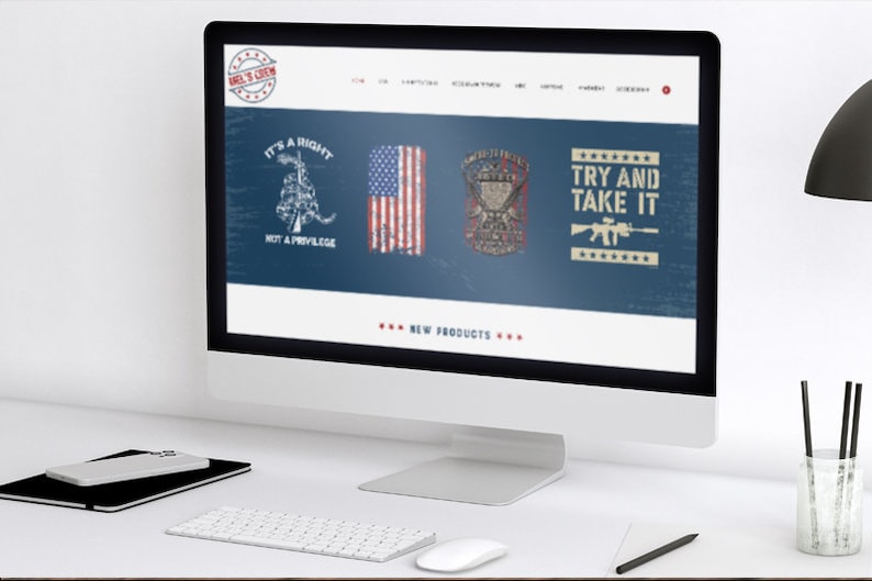 May include: A desktop computer displays a website with patriotic graphics. The website features images of the American flag, military emblems, and text that reads "It's a Right Not a Privilege" and "Try and Take It." The computer sits on a white desk with a keyboard, mouse, and notepad.