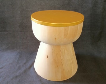 May include: A wooden stool with a gold top. The stool is shaped like an hourglass and has a natural wood finish.