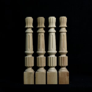 Peut inclure: Quatre balustres en bois non finis avec un motif cannelé et une base carrée.
