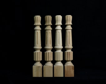 May include: Four unfinished wooden balusters with a fluted design and a square base.