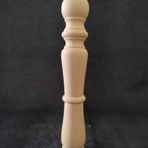 K&ouml;nnte beinhalten: Ein gedrehtes Tischbein aus Holz. Das Bein ist unbehandelt und hat eine glatte Oberfl&auml;che.