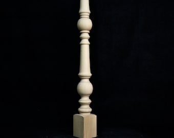 May include: A wooden table leg with a turned design and a square base. The leg is unfinished and has a natural wood color.