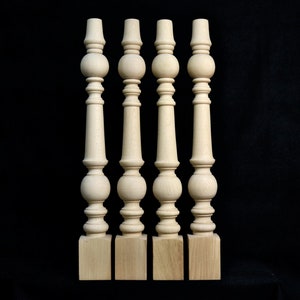 Könnte beinhalten: Vier unbehandelte Holztischbeine mit gedrehtem Design und einer Kugelform an der Oberseite. Die Beine sind etwa 46 cm hoch und haben einen quadratischen Sockel.