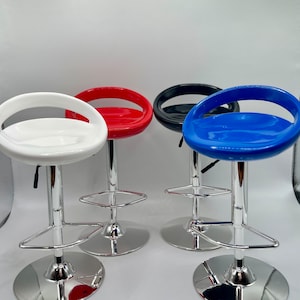 May include: Four bar stools with chrome frames and footrests. The seats are made of glossy plastic and come in white, red, black, and blue.