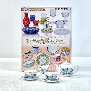 May include: A box set of miniature tableware, including cups, saucers, a teapot, and various glasses and bowls. The set features blue and white floral patterns, along with other decorative designs. The box has Japanese text and the words "Tableware collection".