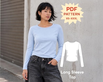 May include: A light blue long-sleeve top with a crew neckline. The image includes a white line drawing of the garment and text that reads PDF PATTERN XS-XXXL and Long Sleeve Top. The top is worn with dark gray denim jeans.