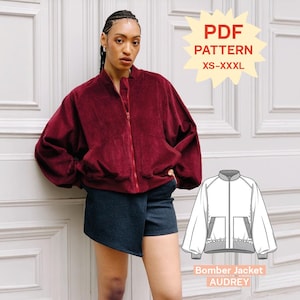 Puede incluir: Una chaqueta bomber de pana color rojo oscuro con cremallera frontal, mangas largas y dos bolsillos delanteros. La imagen incluye una etiqueta de patrón PDF para tallas XS-XXXL y un dibujo técnico Bomber Jacket AUDREY.